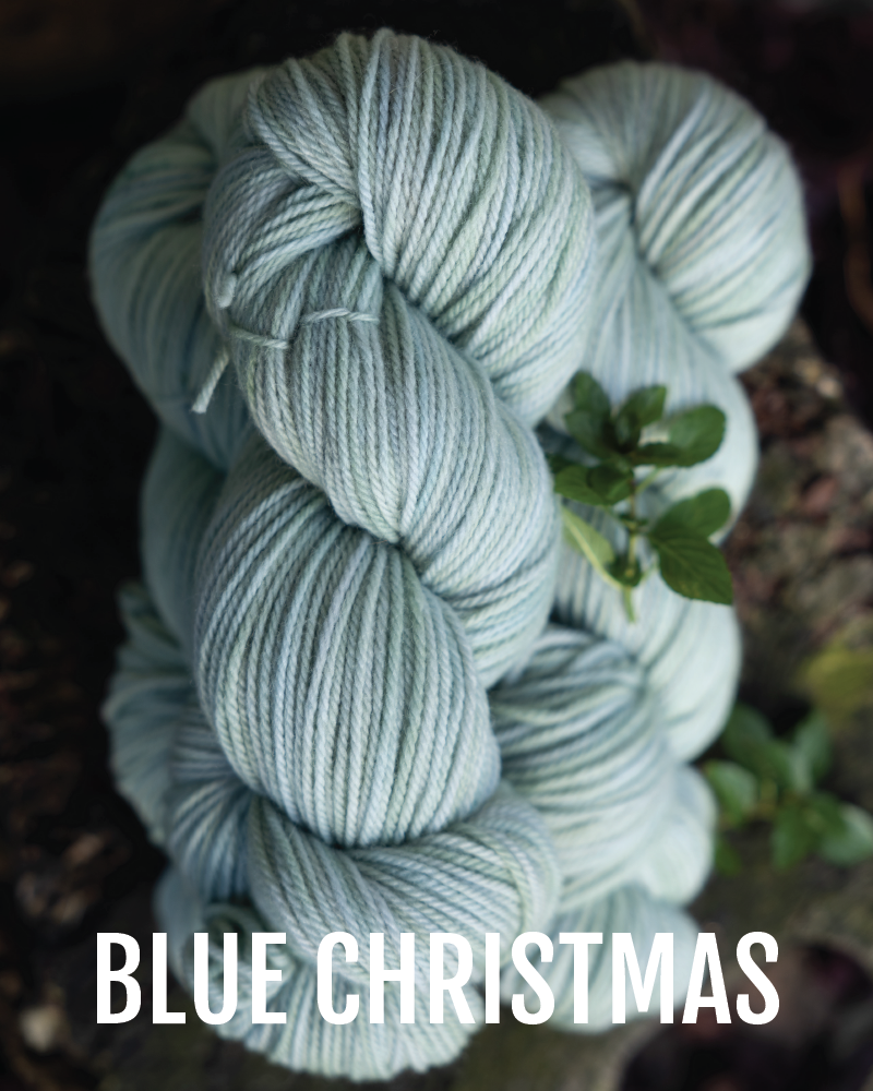 A stack of hand-dyed worsted weight  yarn in a light blue